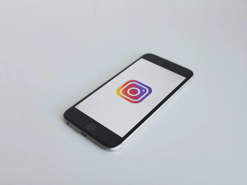 Smartphone con il logo di Instagram su un piano chiaro: quanto costa la gestione dei social