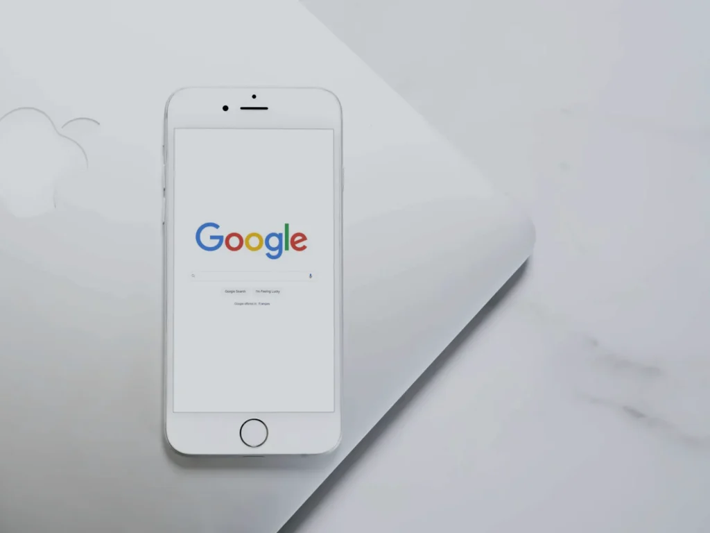 Smartphone con la pagina di ricerca di Google su un piano chiaro: come creare una campagna Google Ads